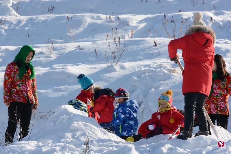 来堆雪人的雪村游客。