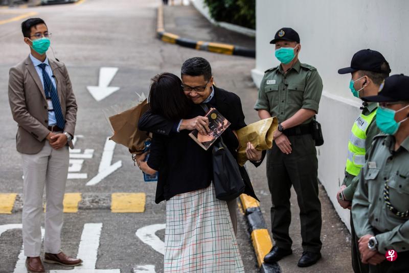 香港“占中三子”之一的陈健民（中）昨天出狱后和妻子拥抱。（法新社）