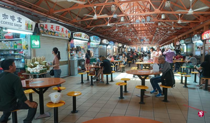 往常午餐时间人潮拥挤的麦士威路熟食中心，如今大部分档口无人排队，半数桌椅空着。（郑雯婕摄）