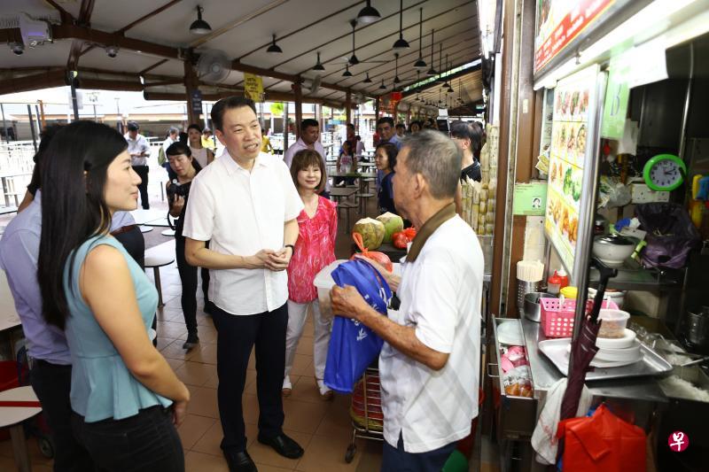 环境及水源部兼卫生部高级政务部长许连碹博士（左三）昨天与负责纽顿小贩中心所在地区的丹戎巴葛集选区议员杨益财（左二），以及联合利华国际的职员，分发关怀礼包给小贩。（林明顺摄）