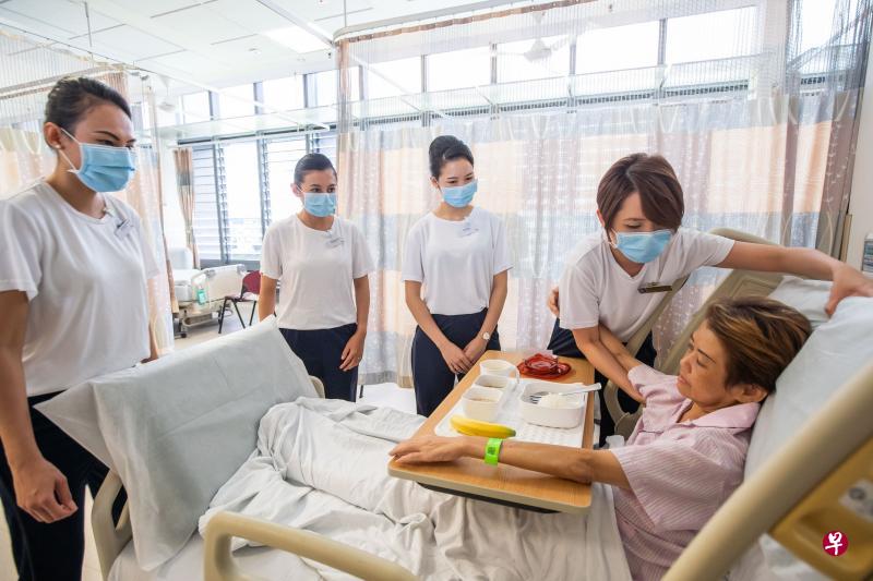 邱德拔医院的护士（右二）向在场的新航空姐示范如何帮助病患在病床上坐立，好让病患能用餐。（邱德拔医院提供）