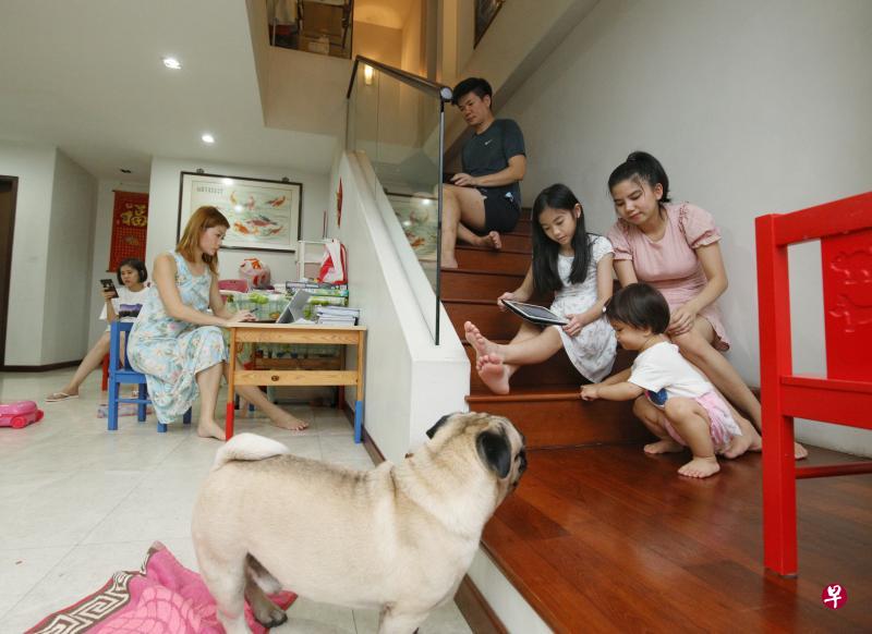 九人大家庭同住一屋檐下，蔡姗珊（左二）和蔡旷扬（中）如今在家中除了要各自找角落应付工作之外，还得照看自己的孩子。（林泽锐摄）