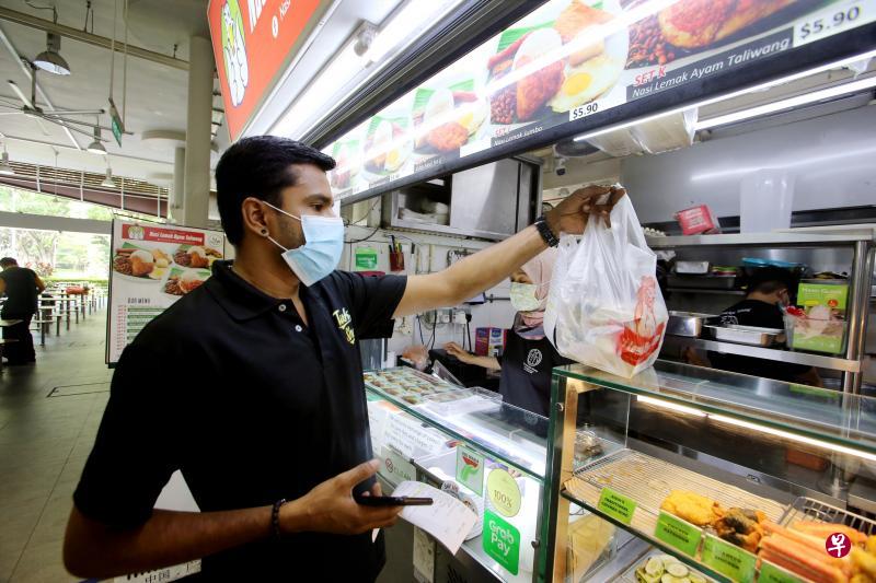 登录义顺公园小贩中心网页订餐的顾客可以选择任何一个摊位的食物，管理小贩中心的Timbre集团接获订单后，会派工作人员（图）到个别的摊位领取食物交给送餐员。摊主无须支付任何送餐费。（严宣融摄）