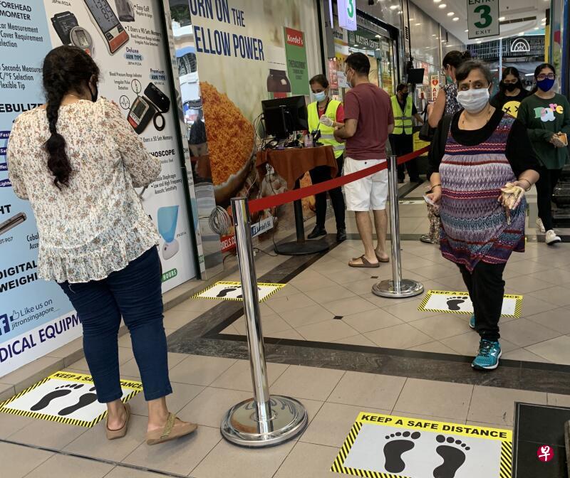 顾客要进入购物中心之前必须先排队，并遵守一米的安全距离。（曾美玲摄）