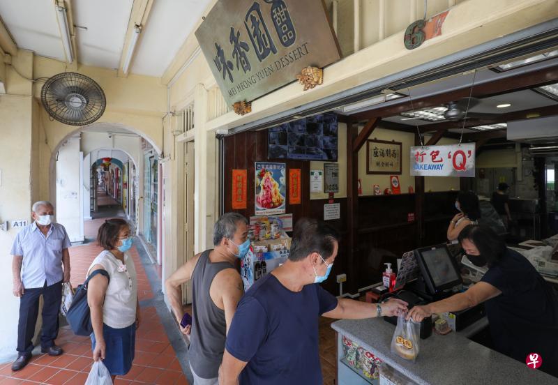 位于牛车水登婆街的甜品店老字号味香园昨天恢复营业，吸引不少老饕驻足，外带几碗甜品回家享用。（林泽锐摄）