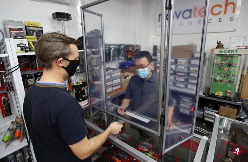 户外运动用品商Novatech常务董事林民福（右）决定在柜台上增设间隔版，增加多一层保护。（李健玮摄）