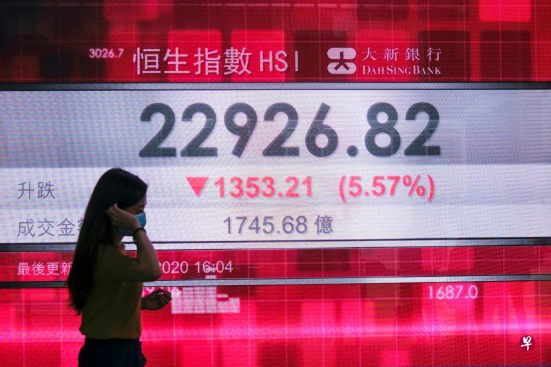 恒生指数去年4月至8月从峰值跌至谷底，跌幅为17.8％，今年冠病疫情也曾导致恐慌性抛售，但昨日的跌幅超过之前的任何一天。图为香港一名女子昨天走过展示恒指数据的电子屏幕。（路透社）