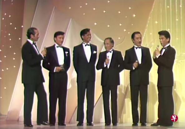 1985年的香港小姐竞选，主持阵容空前鼎盛：（左起）何鸿燊、谢贤、周润发、楚原、杨群、何守信。（网络截图） 