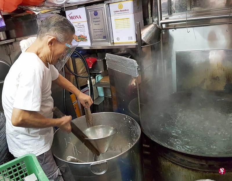 在锦茂熟食中心卖水粿的李三峇，昨天到摊位准备要售卖的食物时，戴着女儿帮他买的面罩。（魏瑜嶙摄）