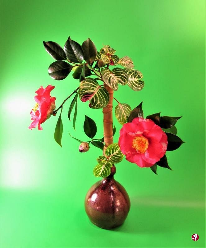 《花棚竹荫呷小杯》——西方传统绘画用透视法（远景小近景大）来处理画面。到了19世纪，法国印象派画家塞尚（Paul Cezanne）分析一切物象都是几何式样，他以自己的构思，把物象几何化，重置在画面上。塞尚的想法突破了传统，开启了现代艺术的大门。本作品以直线和横线构筑的几何空间来创作。（李国雄作品）