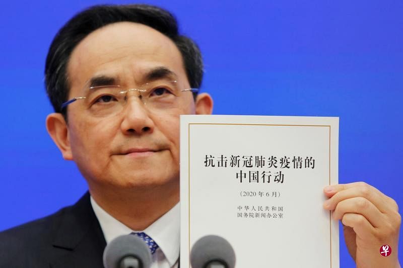 中共中央宣传部副部长、国务院新闻办公室主任徐麟昨天在新闻发布会上，展示《抗击新冠肺炎疫情的中国行动》白皮书。（路透社）