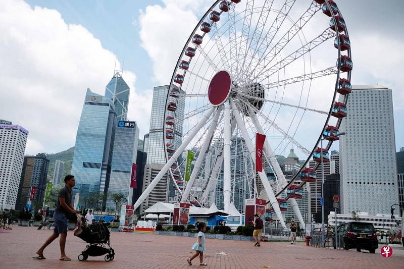 5月访港旅客人数大跌，香港旅发局转而鼓励港人就地旅游消费。图为5月15日经过港岛中环摩天轮的途人。（香港中通社）
