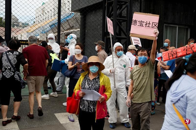 北京突然暴发一波冠病疫情，新发地市场人员和周边居民昨天到广安体育中心接受冠病检测。（路透社）
