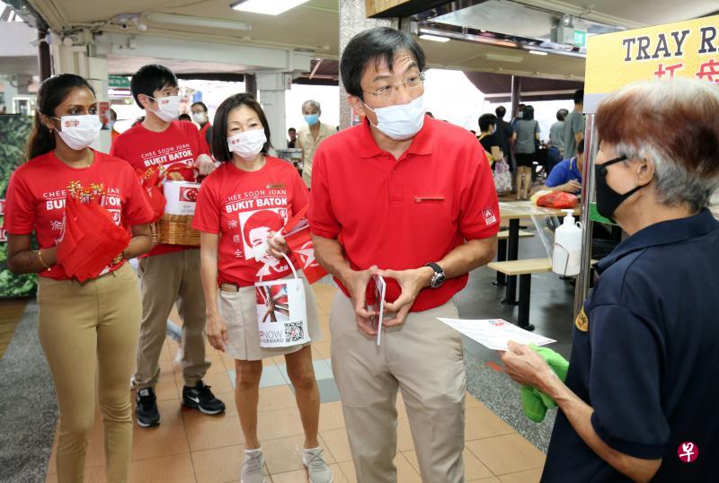 新加坡民主党秘书长徐顺全（右二）昨天走访武吉巴督单选区。徐顺全背后的党员和义工身穿印有他的肖像、名字，以及“Bukit Batok”（武吉巴督）字样的T恤，向居民发出他将再次角逐该区议席的明确信息。（梁麒麟摄）