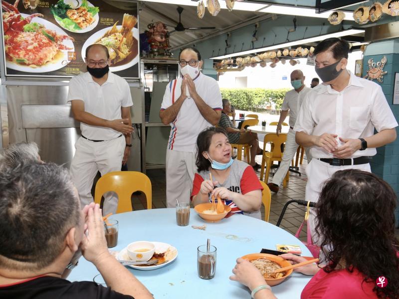 领军人民行动党西海岸团队的通讯及新闻部长易华仁（后排中）昨早在裕廊集选区原议员洪维能（后排右一）和蔡厝港集选区原议员余家兴（后排左一）的陪同下走访南洋区市镇中心。（邬福梁摄）