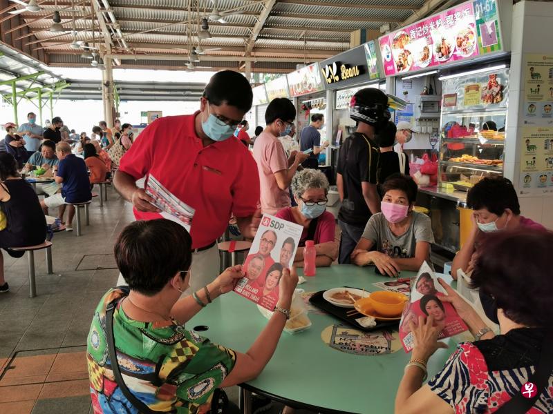  民主党候选人戈麦斯（红衣，左）今早与锦茂熟食中心的居民交流。（陈宇昕摄） 