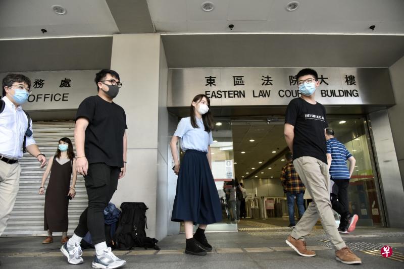 黄之锋（右一）、林朗彦（左二）、周庭（右二）昨天获准保释，走出东区裁判法院提堂。（香港中通社）
