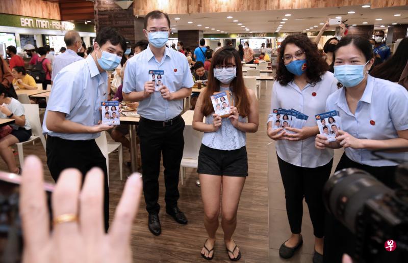 工人党盛港集选区竞选团队昨天到鲤河大厦派发竞选传单。图为候选人林志蔚（左一）、蔡庆威（左二）、辣玉莎（右二）与何廷儒（右一）与年轻居民合影。（梁麒麟摄）
