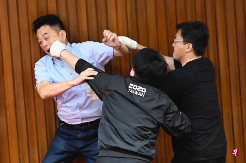 国民党立委鲁明哲（左）与民进党立委吴秉叡（中）、张廖万坚在议场内打成一团。（法新社）