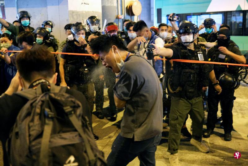 明天是香港反修例抗争中元朗打人事件发生一周年，昨天有市民在元朗西铁站及YOHO MALL游行示威，抗议警察与黑道人士勾结，并呼喊港独口号。警方举紫旗警告在场示威人士违反国安法，便衣警员向一名示威者喷射胡椒剂。（路透社）