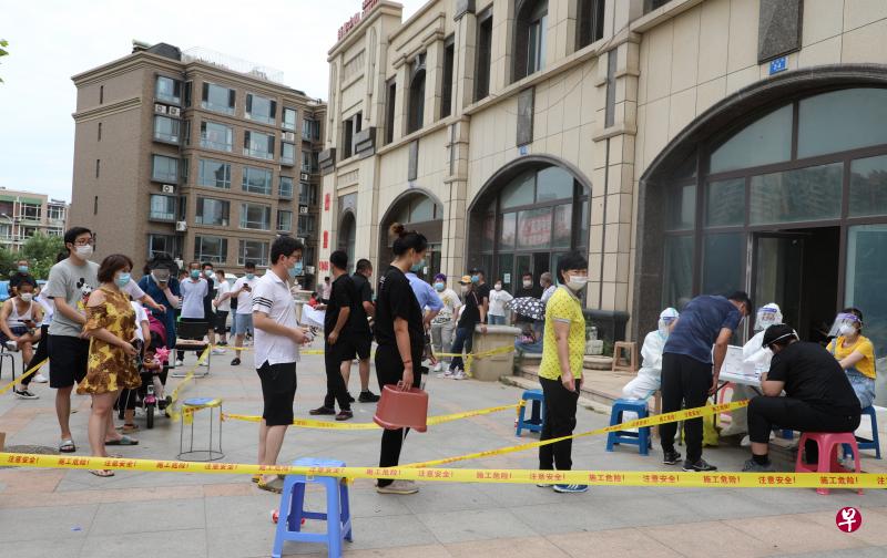 中国辽宁昨天新增14例冠病本土确诊病例，均发生在大连市，官方也已在大连全市范围内开展免费核酸检测。图为大连市民昨天排队进行核酸检测。（中新社）