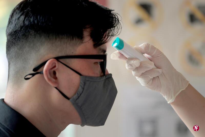 近来为了方便追踪冠病患者，许多公共场所和购物商场都在入口处安排人员，监督来客扫描QR码和测量体温。（档案照）