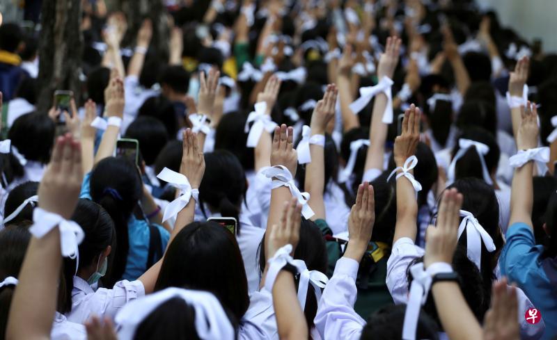 泰国的民主运动扩大到高中学府。周三在曼谷的泰国教育部门外，大批身穿校服的高中生聚集示威，抗议教育制度僵化过时。他们用白丝带扎头发、系在手腕或书包上，表示与民主改革紧紧团结。（法新社）