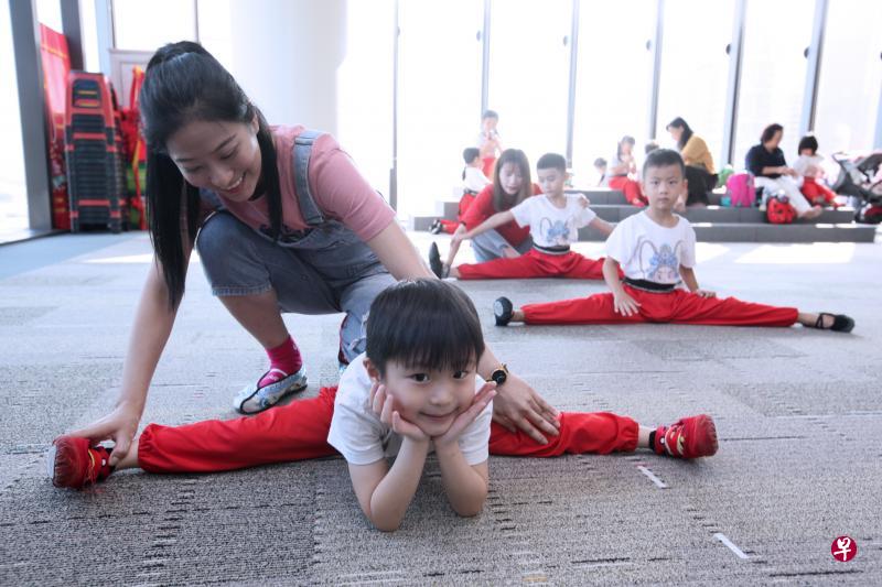 指导员黄琳琳教导从4岁开始学潮剧的小学员郑镜准（现6岁）练习劈叉一字马。