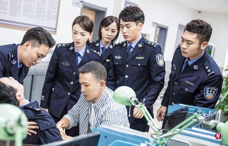 吴谨言在《幸福还会来敲门》首次演警察（后排左二），三度搭档的聂远饰演医生（前排右）。（互联网）
