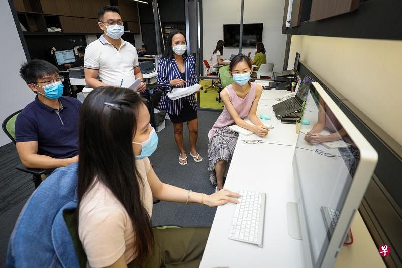 茵丹（站立者右一）求职一年之后终于在室内设计与装修公司WEDA找到工作。她的雇主梁铭生（站立者右二）使用网站“人才推荐”功能寻找合适求职者时，发现茵丹的经验和技能符合公司的需要，主动邀请茵丹面试。（林泽锐摄）