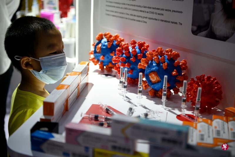 一个男孩在9月6日的北京国际服贸会上注视着科兴生物参展的候选疫苗。人们期待疫苗能遏制疫情。