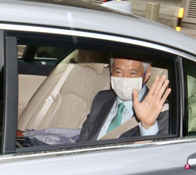 李显龙总理昨天上午乘车抵达最高法院停车场出席诽谤案审讯，向在场等候的媒体挥手。（邬福梁摄）