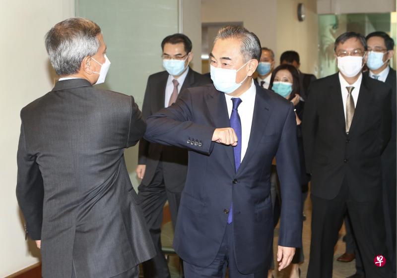 我国外交部长维文医生（左一）和中国国务委员兼外交部长王毅（左三），昨天在樟宜机场贵宾室会面时，以互碰对方手肘代替握手。王毅背后为新加坡外交部常任秘书池伟强（右二）以及中国驻新加坡大使洪小勇（右一）。（陈斌勤摄）