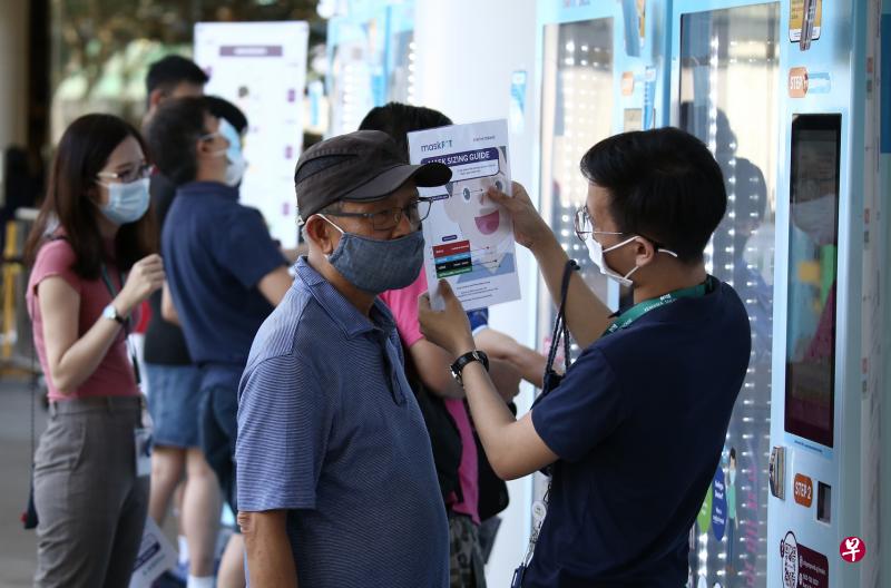 这次的口罩分发活动首次推出不同尺寸的口罩，现场还有服务大使帮忙测量脸型，方便公众领取适合的口罩。（陈渊庄摄）