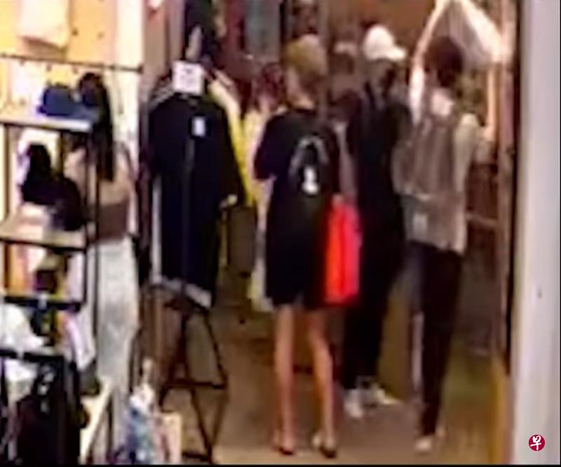 三名男子到店内试穿衣服，一人（右）过后把装着衣服的袋子用双手高高举起走出店外，感应闸门竟然没有响起。（取自Instagram） 