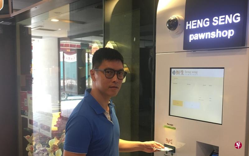 何振华示范如何在自动化终端机上扫描当票条码，然后以现金支付续当利息，这是本地第一家安装这种机器的当铺，方便客户全天候续当。（苏秉玲摄） 