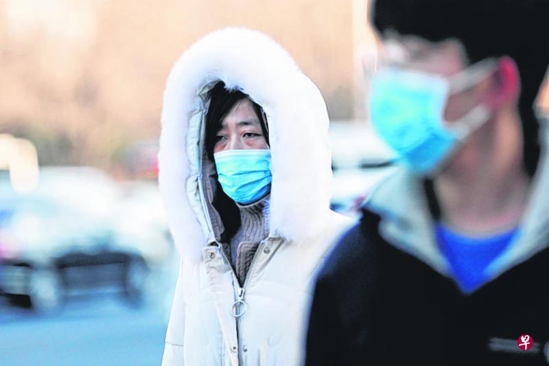 北京进入了秋冬季，寒风凛冽，当地人还是戴上口罩出门。（路透社）