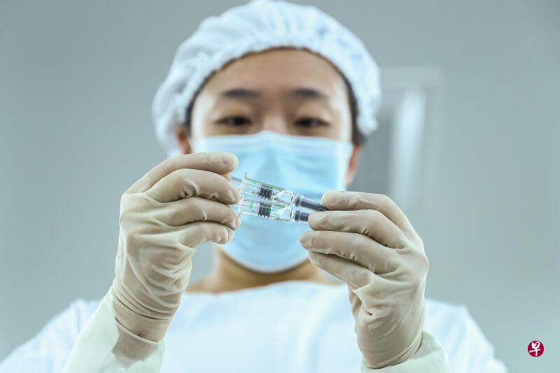 一名工作人员25日在国药集团中国生物北京生物制品研究所包装车间检查灭活疫苗产品的包装质量。（新华社）