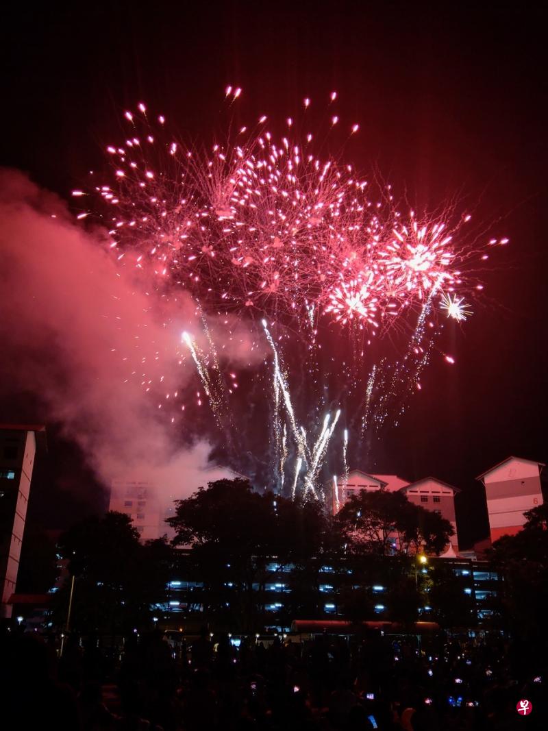烟花爆开的瞬间点亮油池一带的漆黑夜晚，约500多名公众在油池坊附近的空场地赏烟花，不时发出惊叹声。（王嬿婷摄） 