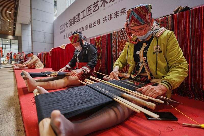 图为12月30日，手工艺人在2020海南自贸港大国非遗工匠艺术珍品展上制作黎锦。（新华社）