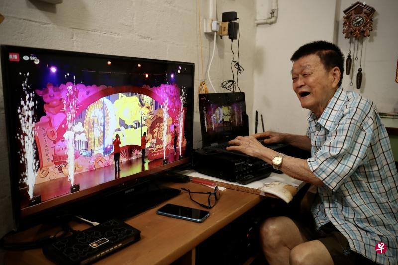 学习电脑约五年的84岁杨朝坤昨天第一次通过面簿直播，观看牛车水亮灯仪式。他说，冠状病毒还在传播中，街上人多，在家看亮灯还是安全些。（陈来福摄）
