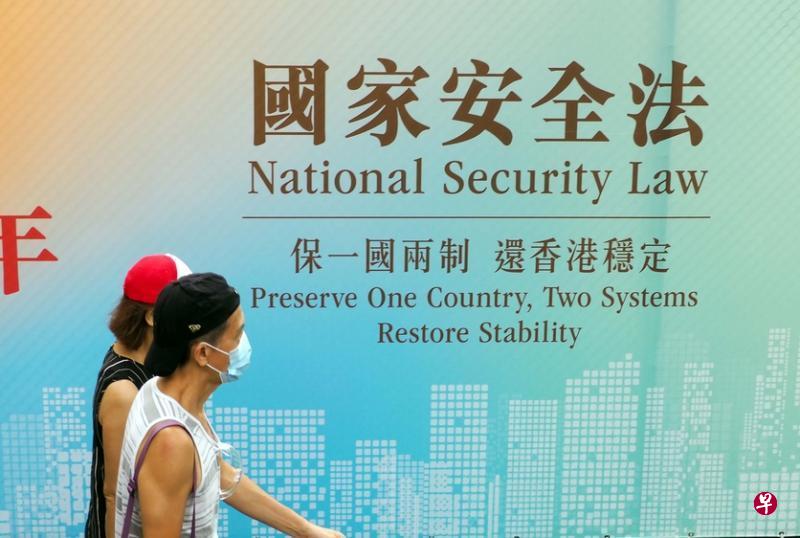 香港市民经过街头宣传“国家安全法”的标语。 （中通社）