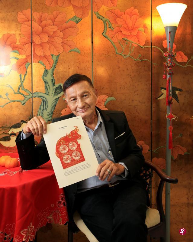 半退休的美术设计师卢家添从生肖邮票获得诸多设计灵感，他手持列支敦士登激光印刷的牛票，取材中国剪纸。（龙国雄摄）