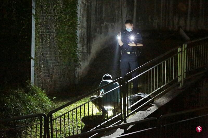 警员手拿着手电筒抹黑调查。