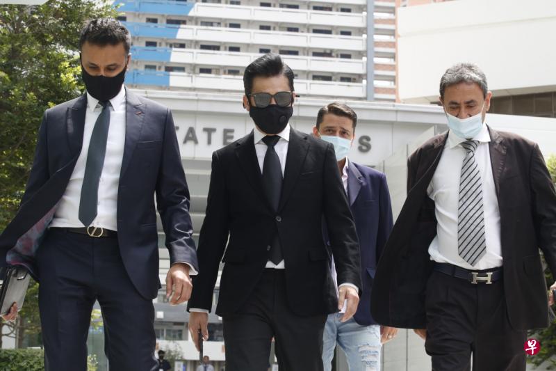 曹国辉（戴墨镜者）今午被控上法庭。（梁麒麟摄） 