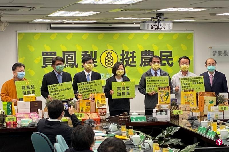 中国大陆近日宣布暂停进口台湾凤梨（新加坡称黄梨），台湾总统兼民进党主席蔡英文（中）本周三召开记者会促销凤梨，为农民打气。（路透社）