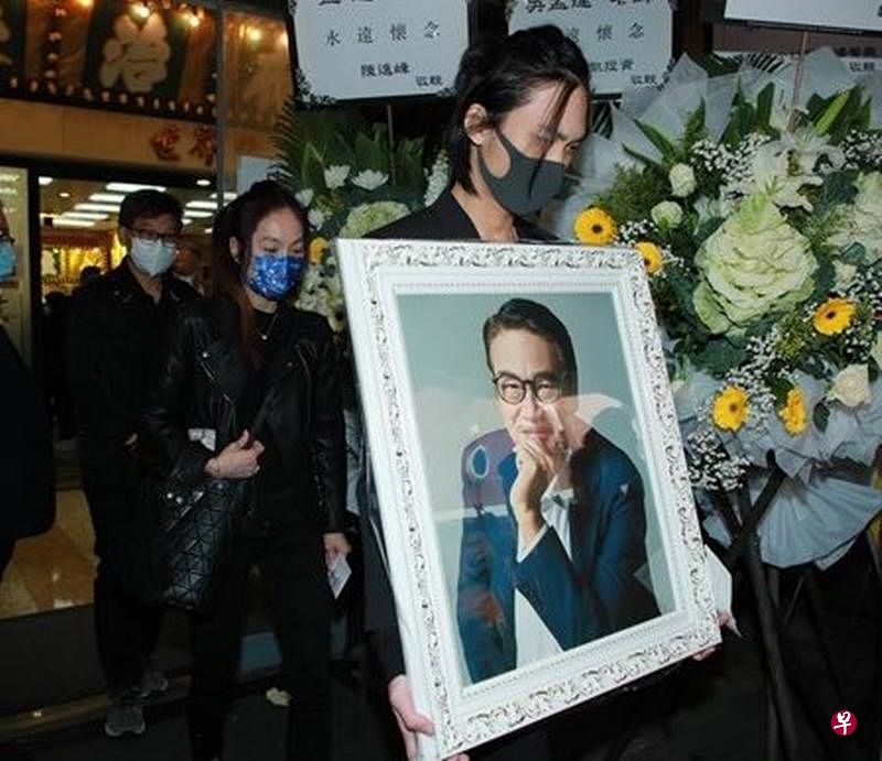 达哥儿子韦仑捧着爸爸的遗照。（互联网）