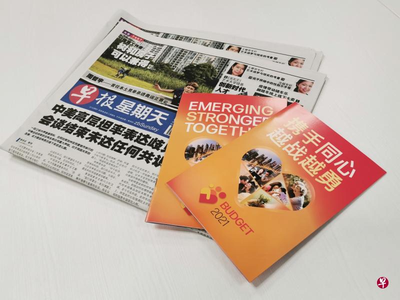 2021年财政预算案小册子随3月21日出版的《联合早报》免费分发给读者。（谢智扬摄） 