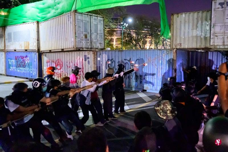 曼谷警方用集装箱阻挡示威者，但他们就用绳索把一些顶层集装箱拉倒在地。（法新社） 