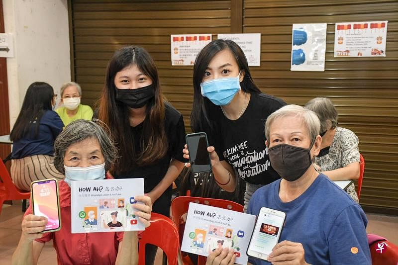 南大义工李睿淳（后排左）与南大生关怀乐龄人士计划Can One Lah！成员李佳倩（后排右）在心愿社区关怀中心教导乐龄人士投过视听媒介学习智能手机的基本应用程序及使用方法。（受访者提供） 